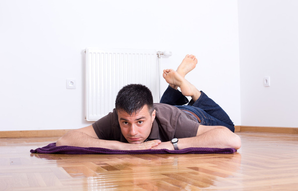 Άντρας ξαπλωμένος στο πάτωμα στο στομάχι - Φωτογραφία, εικόνα