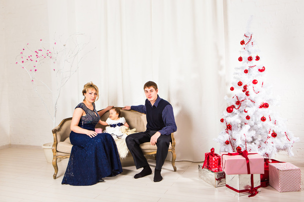 Різдвяна сім'я з трьох осіб і ялинка з подарунковими коробками
 - Фото, зображення