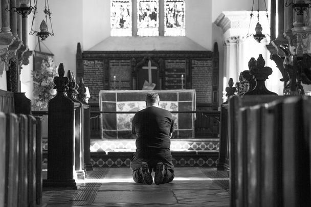 El hombre arrodillado ante el altar
 - Foto, Imagen