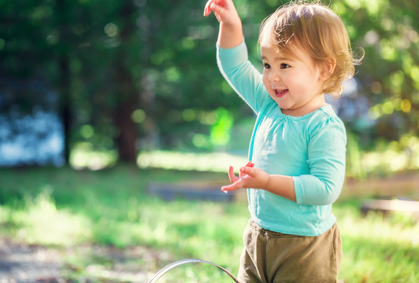Happy toddler girl smiling and playing outside - Fotoğraf, Görsel