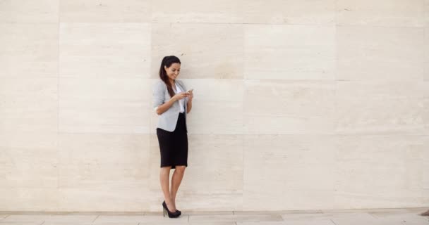 Empresária elegante em pé contra uma parede
 - Filmagem, Vídeo