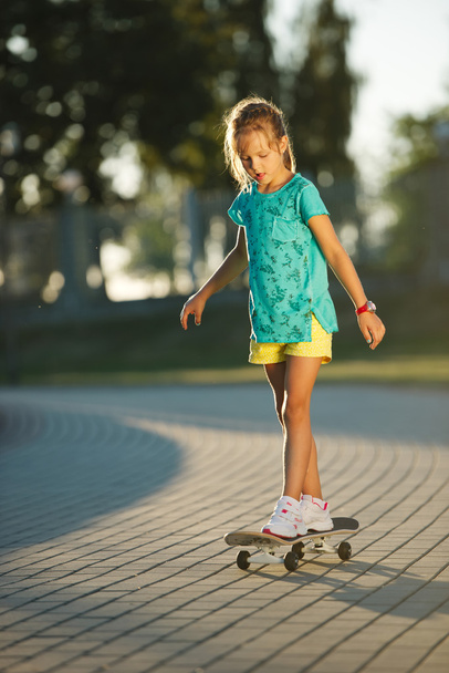 cute little girl with skateboard outdoors - 写真・画像