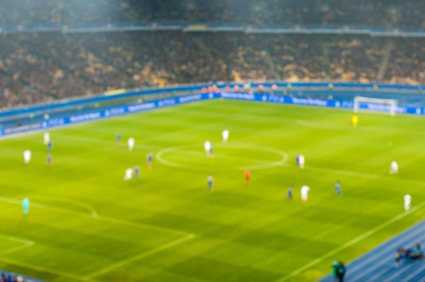 Rozmazané fotbal nebo fotbal hráči na hřišti během zápasu. Out-of zaměření pozadí, prázdné místo pro text - Fotografie, Obrázek