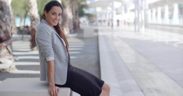 Elegante vrouw zittend op een bankje op een promenade - Video