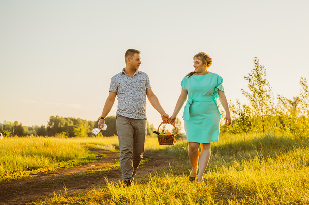 Romantic couple go and holding hands on background summer meadow - Photo, image