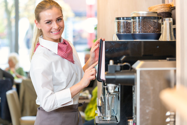 Waitress working at coffee machine in bakery or cafe - Фото, изображение
