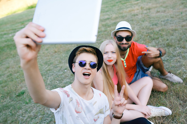 Outdoor Portret van groep van vrienden nemen van foto's met een smartphone in het park - Foto, afbeelding