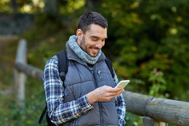 happy man with backpack and smartphone outdoors - Foto, immagini