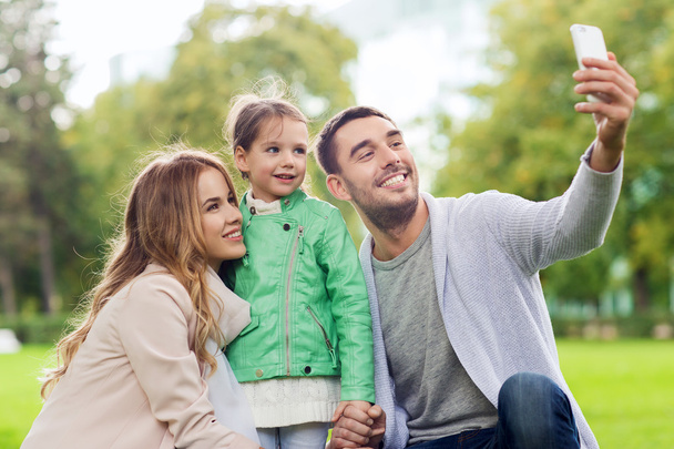 happy family taking selfie by smartphone outdoors - Valokuva, kuva