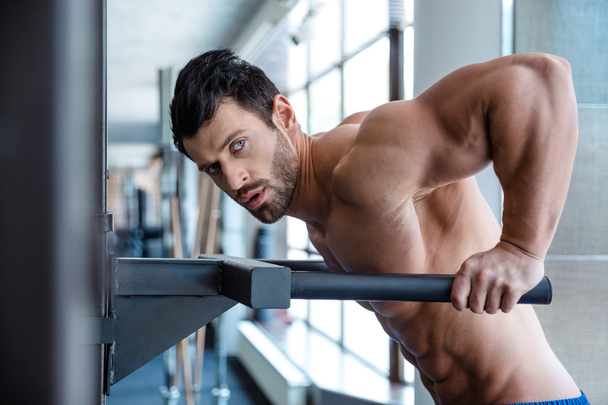 Muscular man workout on parallel bars - Fotografie, Obrázek
