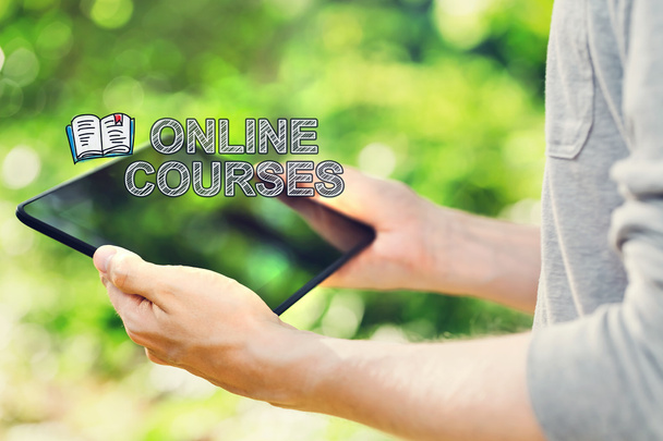 Online Courses concept with man holding his tablet computer - Foto, Imagen