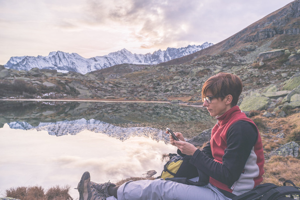 Checking smartphone on scenic mountains - Photo, Image