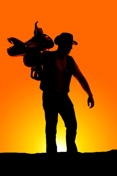 silhouet van cowboy met zadel - Foto, afbeelding