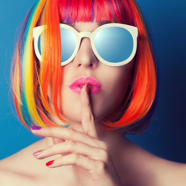 beautiful woman wearing colorful wig and white sunglasses agains - Valokuva, kuva