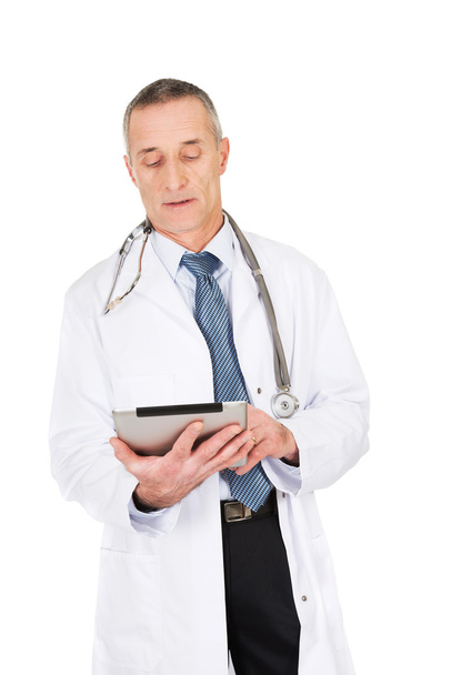 Mature male doctor using a tablet - 写真・画像