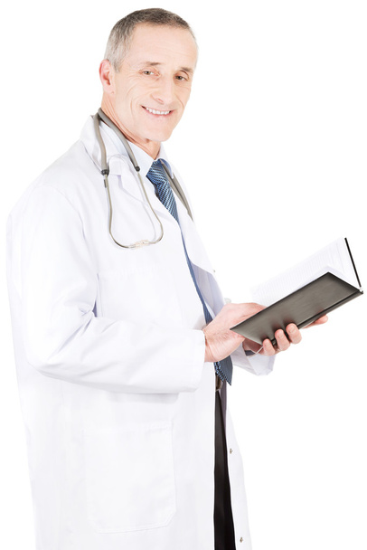 Mature male doctor holding notebook - Fotó, kép