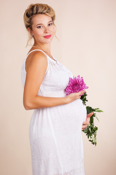 Kobieta w ciąży z różowy kwiat złoty stokrotka - Zdjęcie, obraz