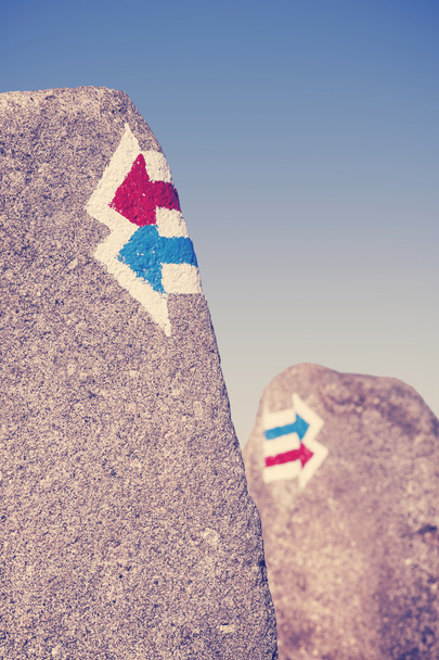 Signos de sendero retro tonificados pintados en roca, elección o cono de dilema
 - Foto, imagen