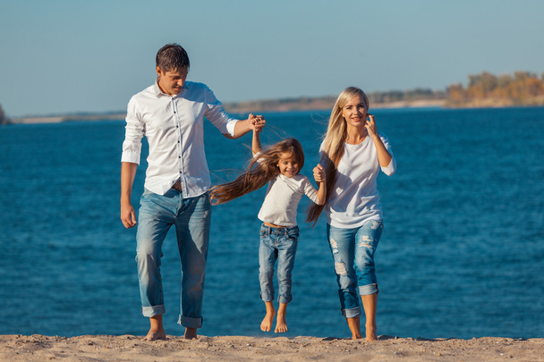 glückliche Familie, die am Strand spielt. Konzept freundlicher Familien - Foto, Bild