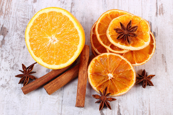 Dried and fresh orange with spices on old wooden background - Foto, afbeelding