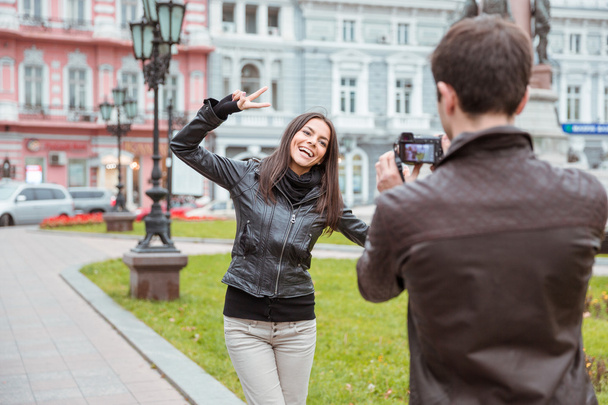 Man making photo of laughing woman outdoors - Photo, image
