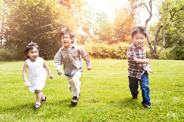 Aasian lapset käynnissä puistossa
 - Valokuva, kuva