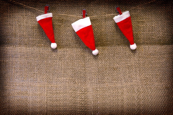 Christmas hats  hanging on brown cloth  background. - Fotó, kép