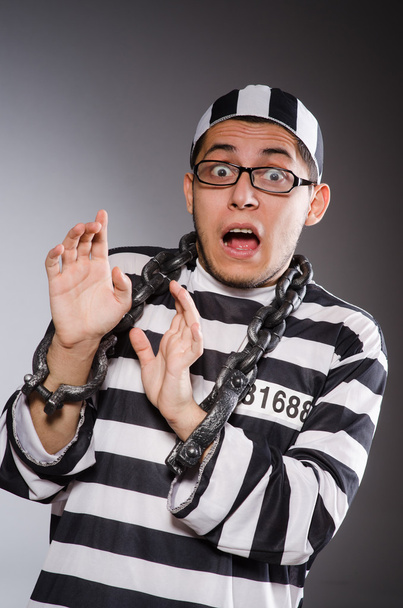 Молодой заключенный в цепях против серого
 - Фото, изображение