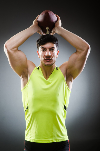 Muscular man with american football - Foto, afbeelding