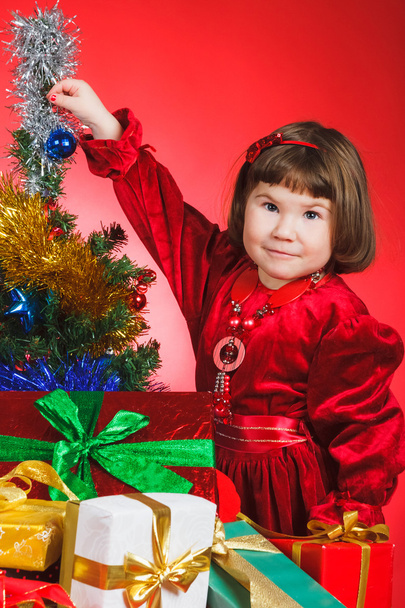 Nice child standing nearby Christmas tree - Valokuva, kuva