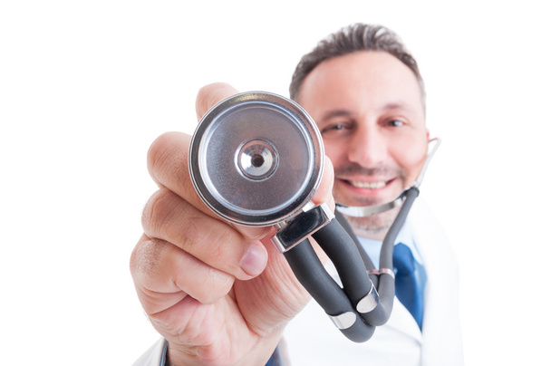 Medic or doctor holding stethoscope with focus on it - Φωτογραφία, εικόνα