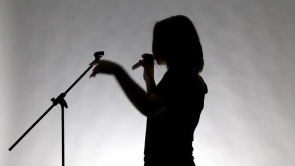 Black silhouette of teenage girl singing - Footage, Video