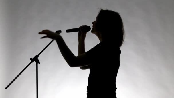 schwarze Silhouette eines Mädchens mit Mikrofon - Filmmaterial, Video