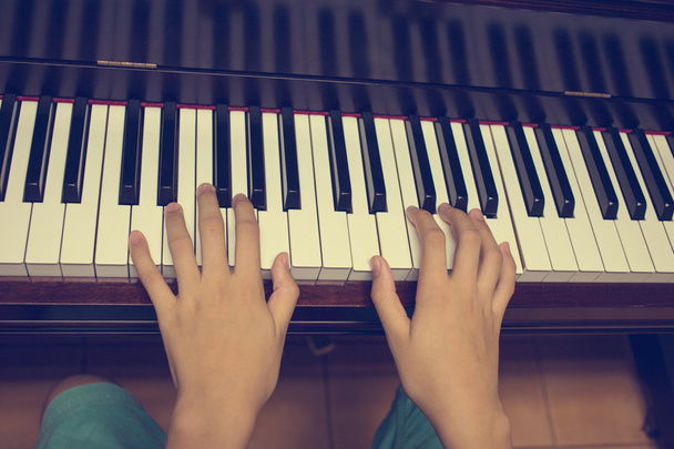 ピアノのキーボードの女の子の手: ビンテージ フィルター - 写真・画像