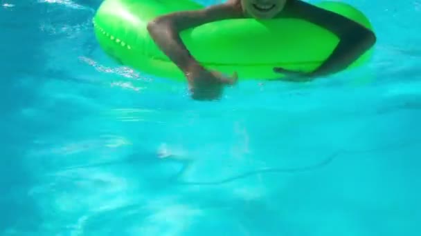 Niños sentados en anillo inflable en piscina
 - Imágenes, Vídeo