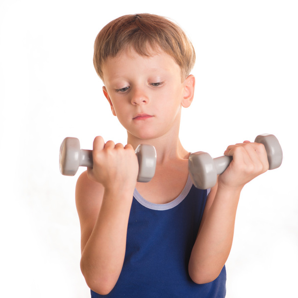 Boy blue shirt doing exercises with dumbbells over white backgro - Foto, afbeelding