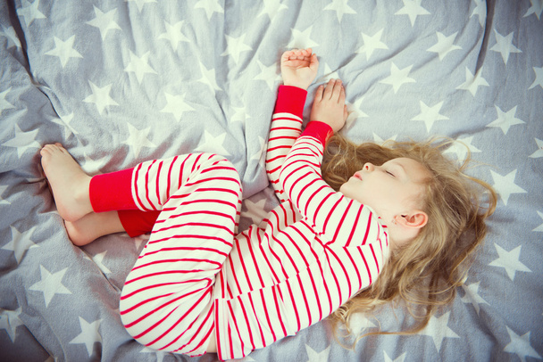 Cute little girl sleeps in pajames on bed - Foto, Imagem