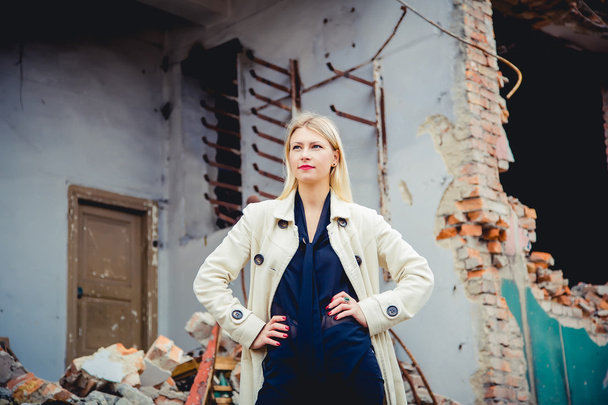 Blonde in the coat on the ruins of the house, beauty - Photo, image