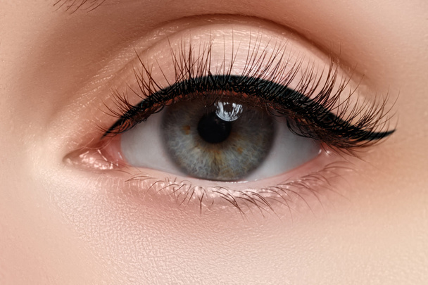 Macro shot of woman's beautiful eye with extremely long eyelashes. Sexy view, sensual look. Female eye with long eyelashes - Fotó, kép