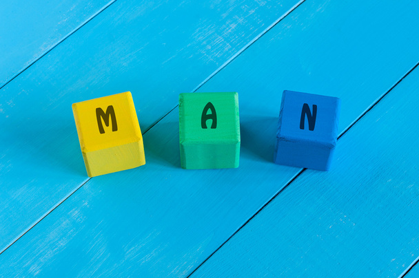 Man - sign on color wooden cubes with light blue wood background. - Фото, зображення