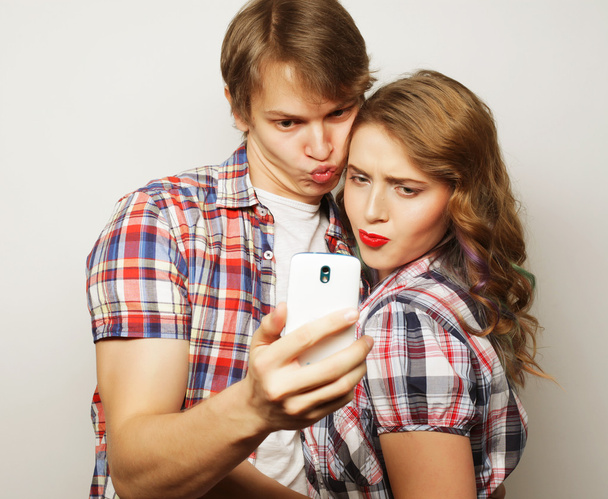 smiling couple with smartphone, selfie and fun. - Fotoğraf, Görsel