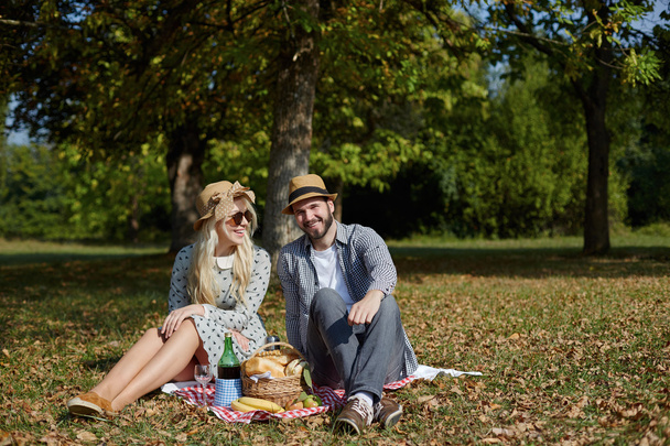 Kaunis nuori pari ottaa piknik maaseudulla. Hyvää perhettä.
 - Valokuva, kuva