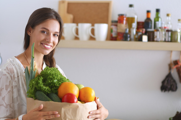 Young woman holding grocery shopping bag with vegetables - Photo, Image