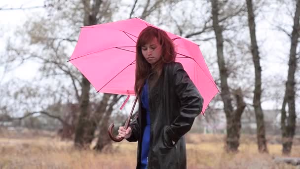 Žena s růžovým deštníkem volá po telefonu - Záběry, video