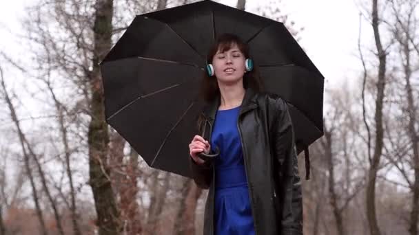 Kobieta w deszczu słucha muzyki - Materiał filmowy, wideo