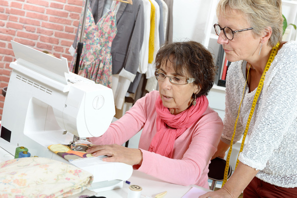 Dos costureras alegres trabajando juntas en su taller
 - Foto, Imagen