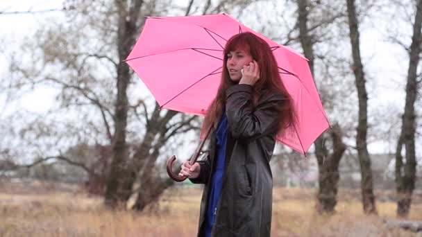 A mulher com telefone em uma capa impermeável
 - Filmagem, Vídeo