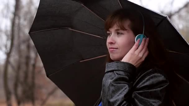 Kobieta w deszczu słucha muzyki - Materiał filmowy, wideo