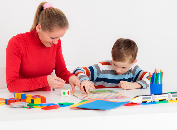 Mom and her son playng at desk - Photo, image