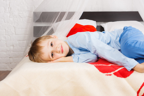 Little boy laying on bed - Valokuva, kuva